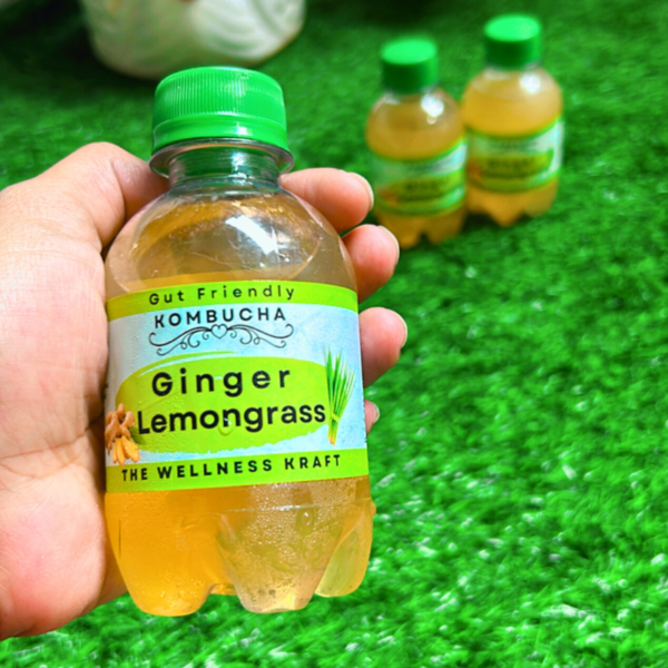 A bottle of The Wellness Kraft Ginger Lemongrass Kombucha, a naturally fermented probiotic drink available in India, with a bold ginger kick and soothing lemongrass notes.