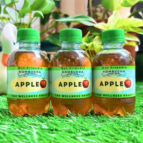 A bottle of The Wellness Kraft Apple Kombucha, a naturally fermented probiotic drink with crisp apple flavor, rich in gut-friendly probiotics and antioxidants.